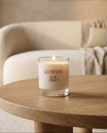 Lucevera candle on a wooden table with a cozy living room background