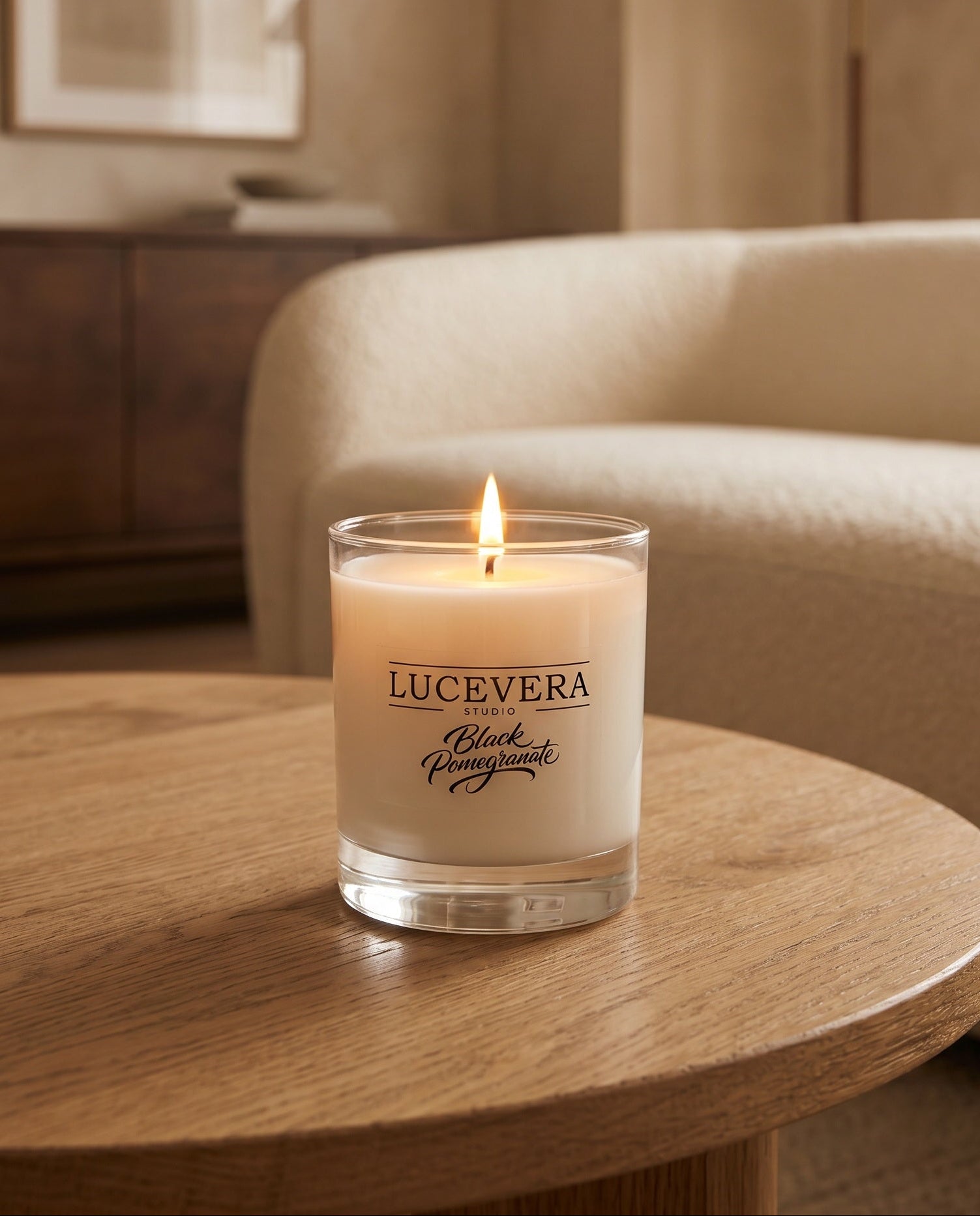Candle with 'Lucevera' branding on a wooden table in a cozy room.