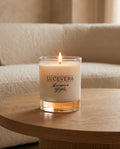 Lucevera candle on a wooden table with a beige sofa in the background